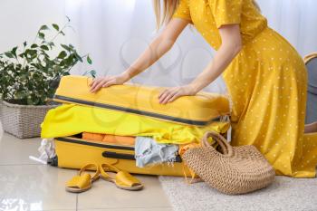 Woman trying to pack belongings at home�