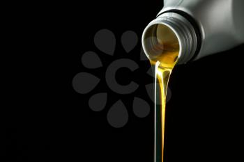 Pouring car oil on dark background�