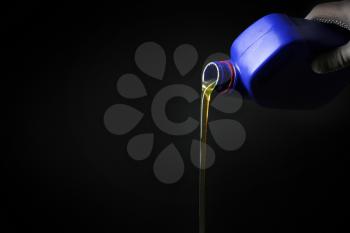 Pouring car oil on dark background�