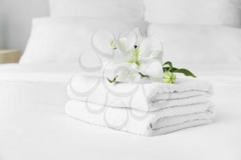 Clean soft towels and flowers on bed�
