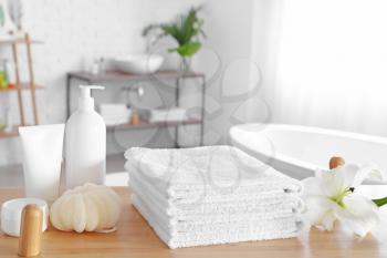 Soft towels and cosmetics on table in bathroom�