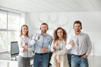 Portrait of technical support agents showing thumb-up in office�