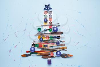 Beautiful Christmas tree made of painter tools on color background�