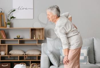 Senior woman suffering from back pain at home�