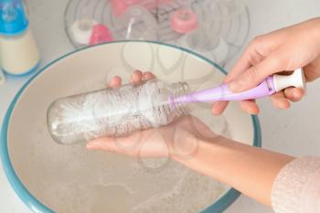 Woman cleaning baby bottle, closeup�