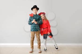 Cute little children with red hearts on grey background. Valentines Day celebration�