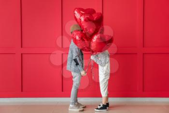 Cute little children with air balloons on color background. Valentines Day celebration�