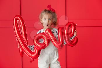 Cute little girl with air balloon in shape of word LOVE on color background. Valentines Day celebration�