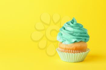 Tasty cupcake on color background�
