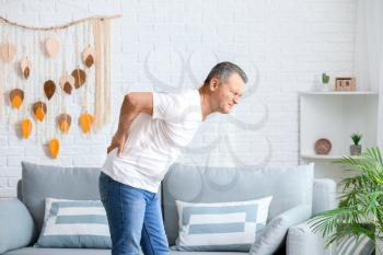 Mature man suffering from back pain at home�