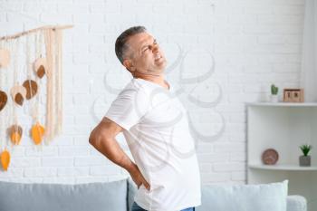 Mature man suffering from back pain at home�