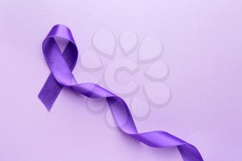 Purple ribbon as symbol of World Cancer Day on color background�