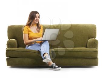 Young woman with laptop sitting on sofa against white background�