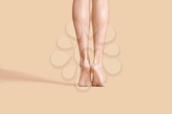 Legs of beautiful young woman on color background�