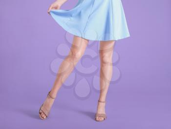 Legs of young woman in stylish shoes on color background�