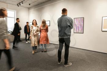Exhibition in modern crowded art gallery�