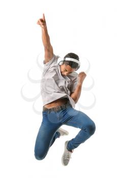Jumping African-American teenager boy with headphones on white background�