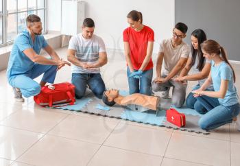 Instructor demonstrating CPR on mannequin at first aid training course�