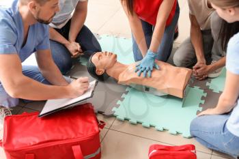 Instructor demonstrating CPR on mannequin at first aid training course�