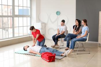 Instructor demonstrating CPR on man at first aid training course�