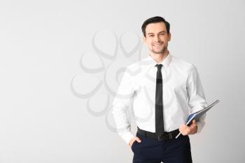 Male real estate agent on light background�