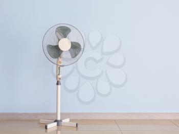 Modern electric fan near color wall�