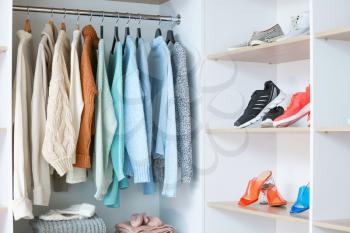 Stylish clothes and shoes in modern store�