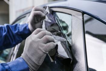 Male worker tinting car window, closeup�