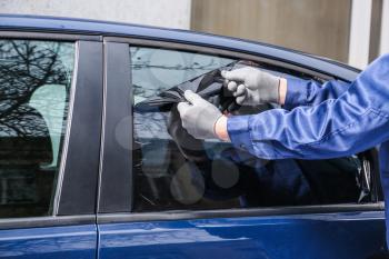 Male worker tinting car window�