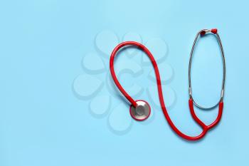 Modern stethoscope on color background�