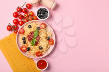 Plate with tasty pasta, olives and tomato sauce on color background�