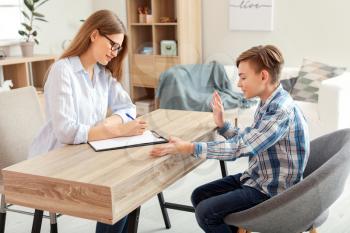 Female psychologist working with boy in office�