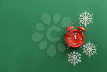 Alarm clock with snowflakes on color background�
