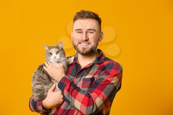 Man with cute cat on color background�