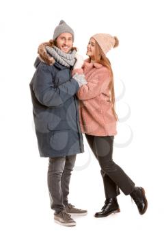 Happy couple in winter clothes on white background�