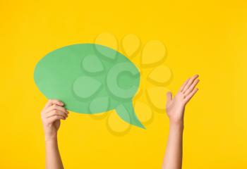 Female hands and blank speech bubble on color background�
