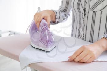 Woman ironing clean clothes at home, closeup�