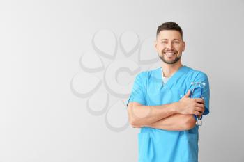 Male cardiologist on light background�