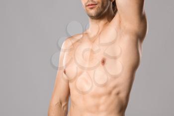 Handsome young man after depilation on grey background�