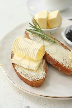 Slices of bread with fresh butter on plate, closeup�