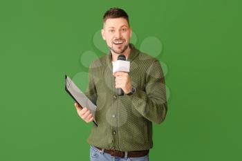 Male journalist with microphone on color background�