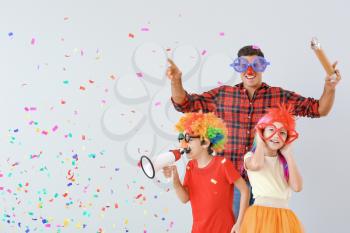Family in funny disguise on light background. April fools' day celebration�