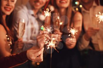 Friends with sparklers celebrating New Year at party�