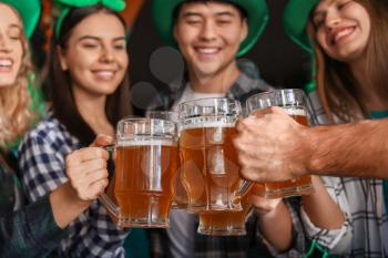 Young friends with beer celebrating St. Patrick's Day in pub�
