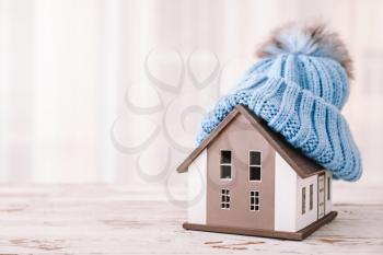 Model of house with hat on table. Winter concept�