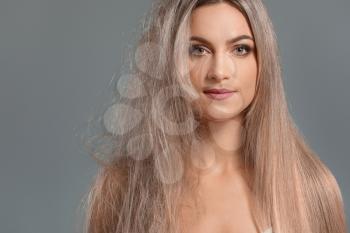 Beautiful young woman before and after hair treatment on grey background�