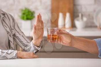Woman refusing to drink whiskey at home. Concept of alcoholism�