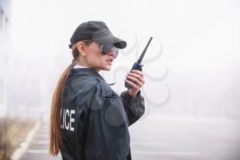 Female police officer patrolling city street�