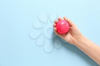 Female hand with stress ball on color background�