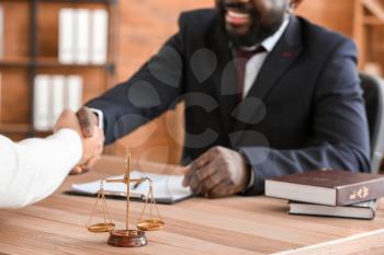 Man and lawyer shaking hands in office�